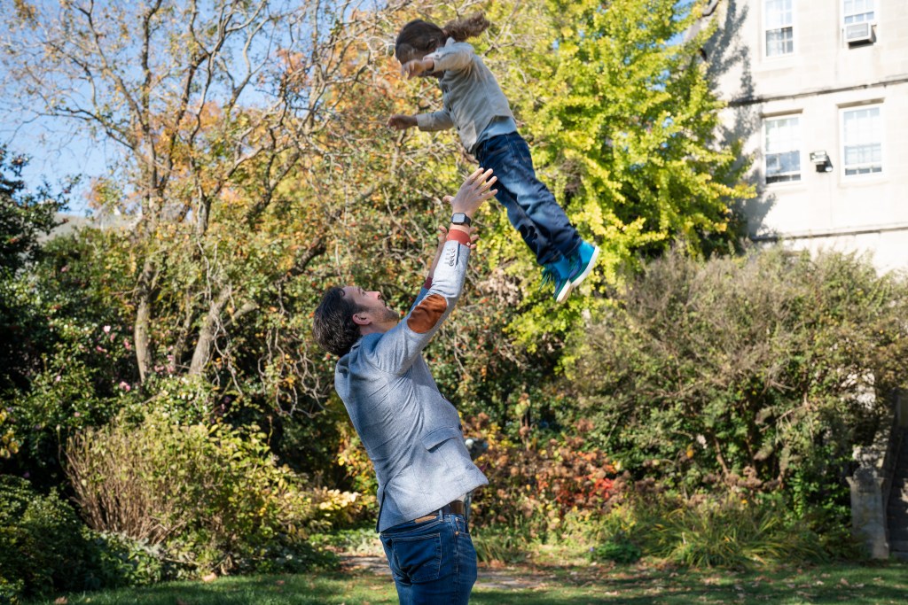 Father lifting his daughter into the air during a family photo session in Washington, DC